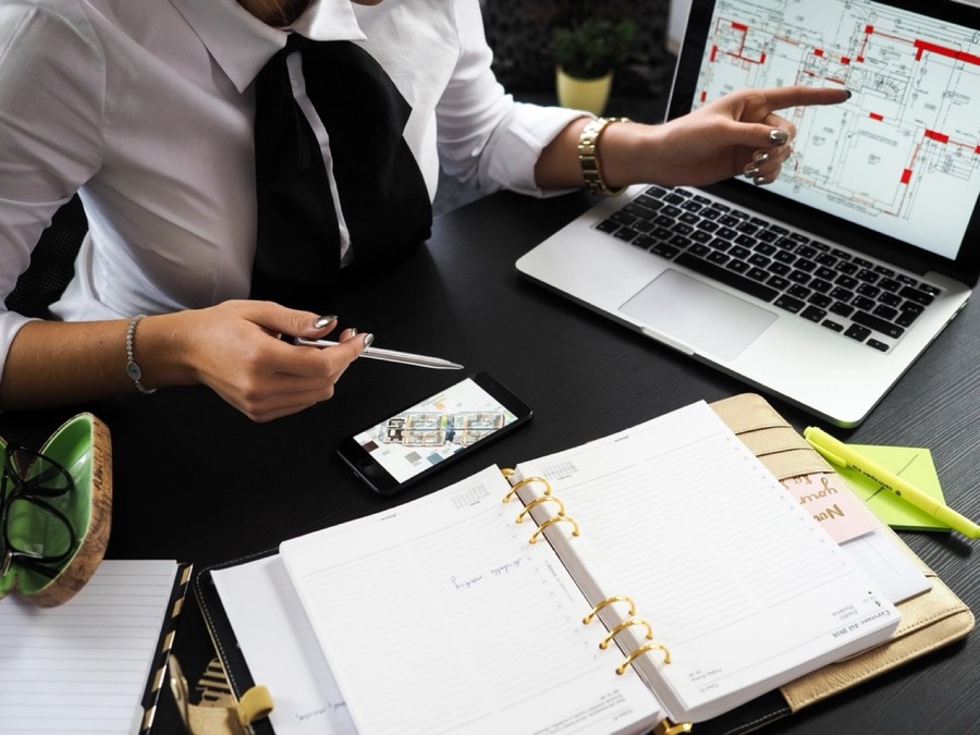 Laptop showing a dashboard next to a phone and notes